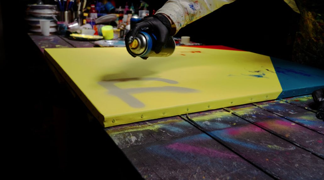 Overlaying graffiti, knife-scraped textures, pipette paint drops, and stencil motifs for a rich, textured background