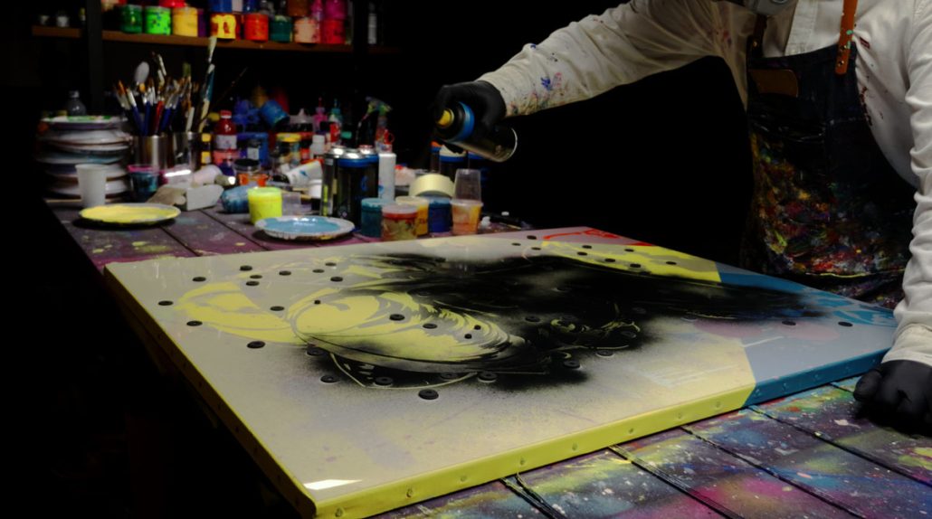 Using the Geisha stencil and spraying black paint to outline the central figure