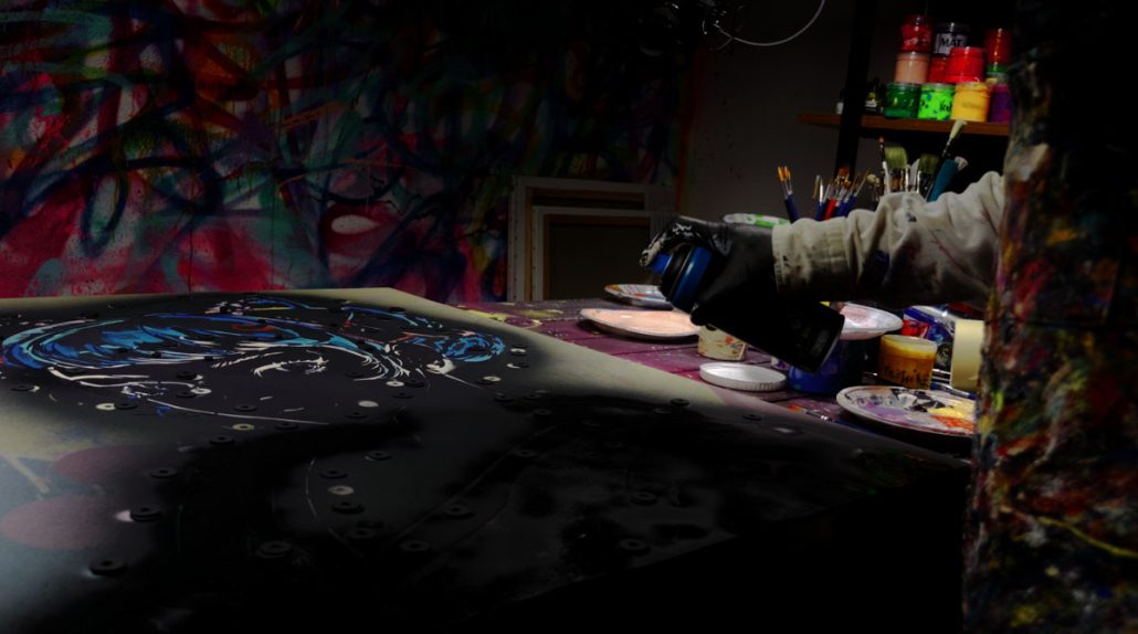 Applying a second layer of black paint using the Geisha stencil to sharpen the figure's outline